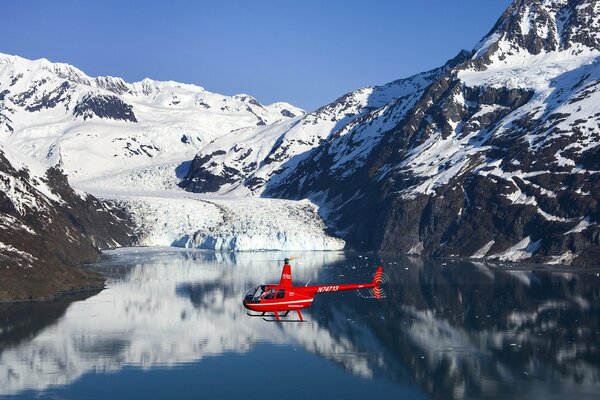 Helicóptero de rescate rojo sobre el lago de montaña
