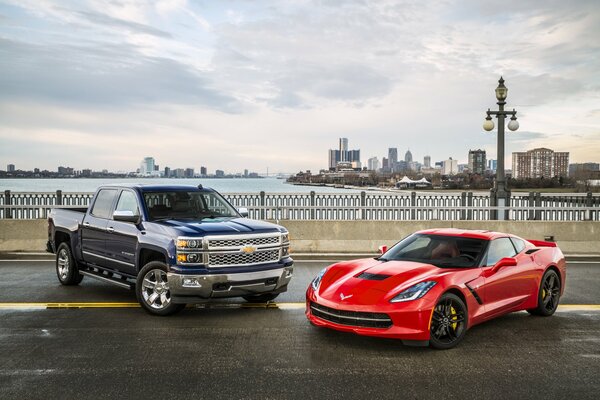 Black Chevrolet Silverado and red Chevrolet Corvette on the embankment