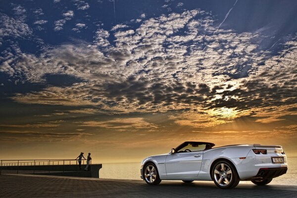 Chevrolet Camaro weißes Cabrio auf Sonnenuntergang Hintergrund