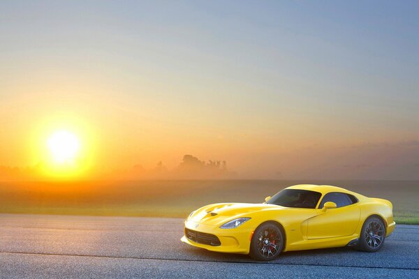 El coche amarillo de un coche extranjero en el fondo del sol
