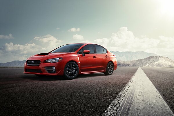 Subaru rouge sur la route goudronnée vide des montagnes chredi