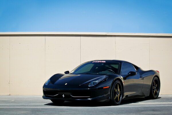 Czarne Ferrari na parkingu przy ścianie