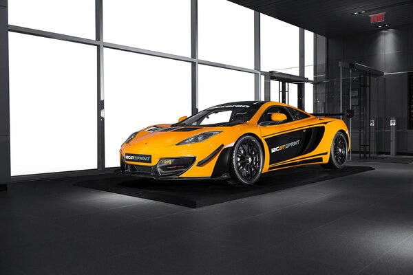 El coche naranja McLaren MP4-12C gt se encuentra en el interior