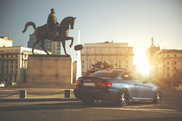 Bmw on the background of the square with a monument