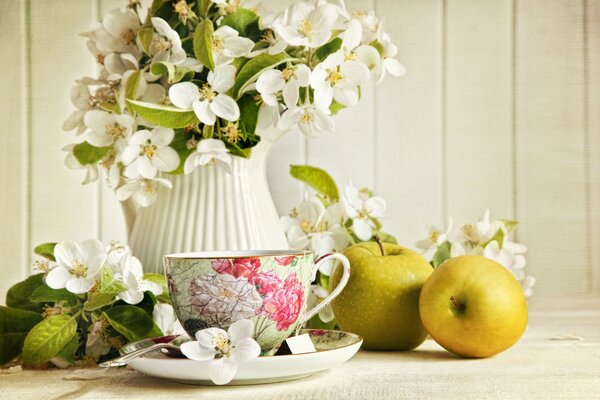 Blumen in einer Vase mit einer Tasse Tee