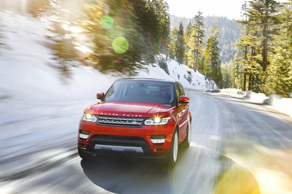 Red range rover on snowy roads