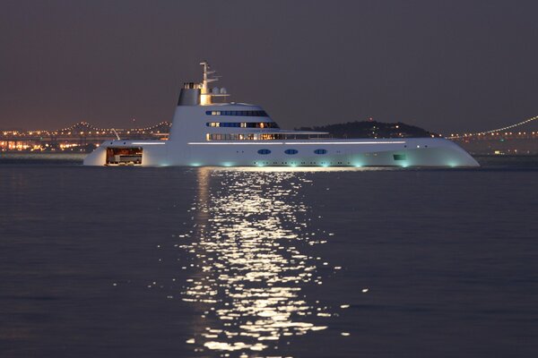 Yate en el mar en medio de un puente y luces en la noche