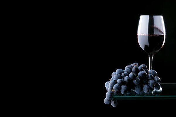 Grappe de raisin et un verre de vin sur une étagère