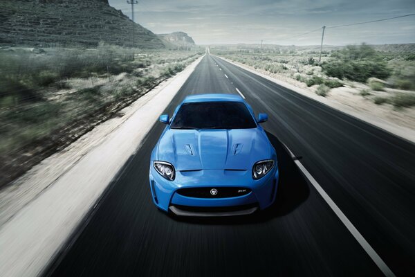 Niebieski samochód jedzie drogą