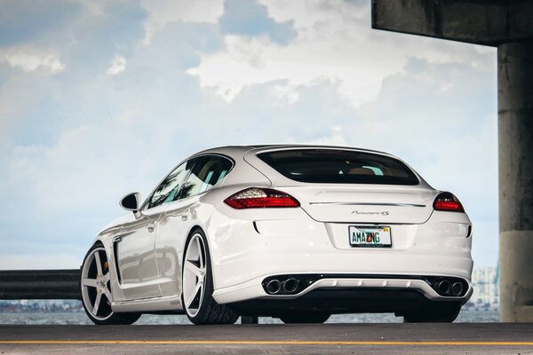 The Porsche, panamera cars have good tuning and beautiful wheels against a beautiful sky and beautiful clouds