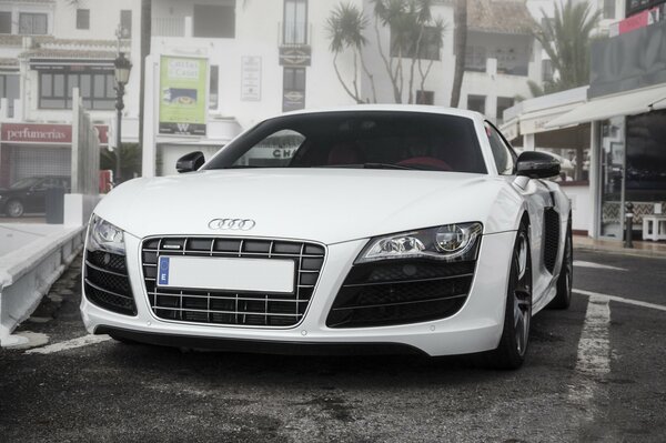 Audi blanco en el estacionamiento cerca de la tienda