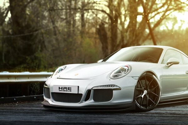 Porsche blanco contra el bosque