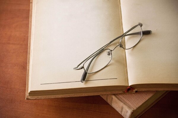 Brille auf einem Buch mit leeren Seiten