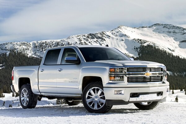 Ein silberner Chevrolet Silverado vor dem Hintergrund der schneebedeckten Berge