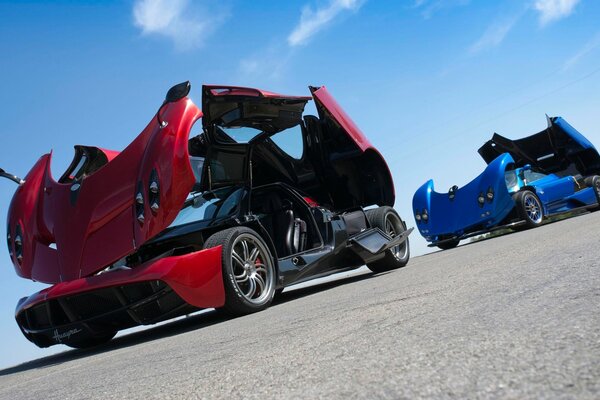 Red and blue supercars under a blue sky