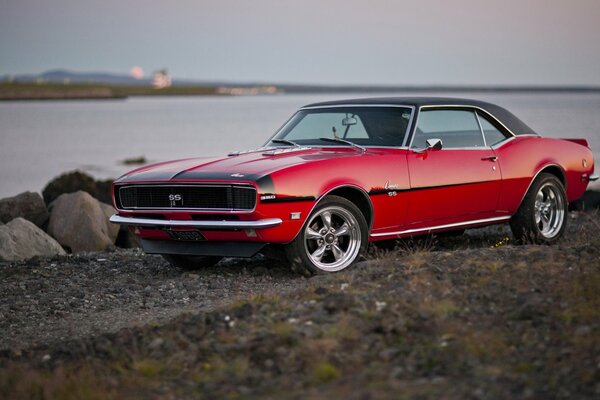 Красный Chevrolet Camaro 1968 на фоне реки