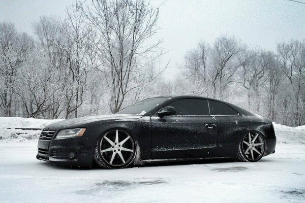 Schwarzer Audi auf Winter Natur Hintergrund