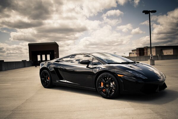 Black Lamborghini on the background of floating clouds