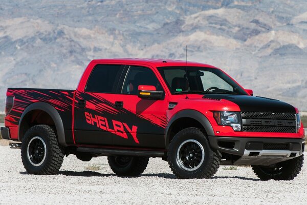 Wallpaper with a red and black shelby pickup truck on the background of snowy mountains