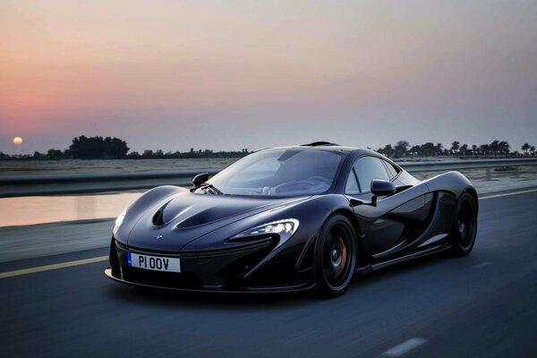 Supercar McLaren nera prima del tramonto serale