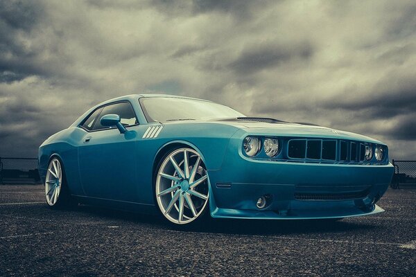 Blue car under gray clouds