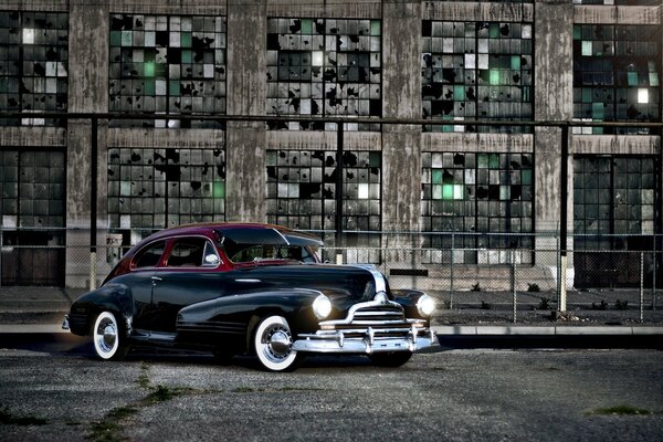 Voiture rctro pontiac47 avec phares allumés sur fond urbain