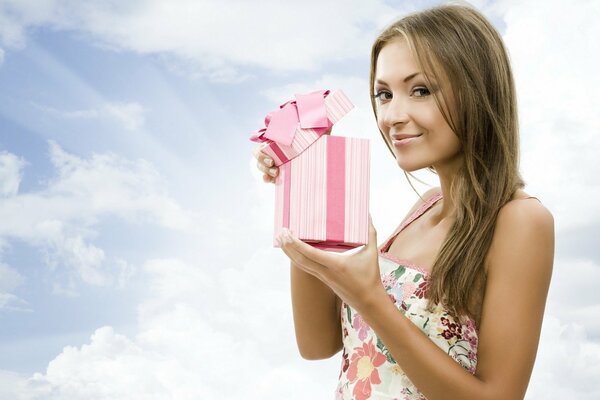 Chica abriendo un atractivo regalo rosa