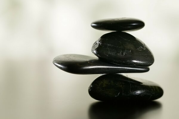 Black stones on a glossy surface