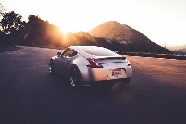 Silver car on the background of the setting sun