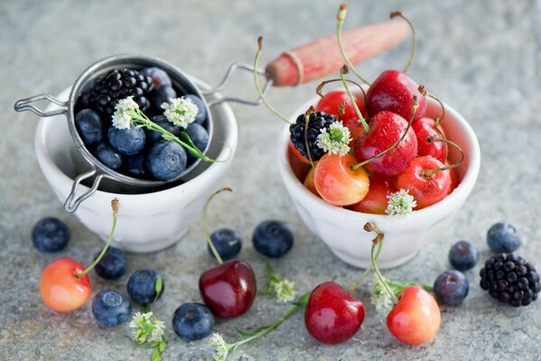 Beeren - Blaubeeren, Brombeeren und Kirschen in weißen Glasschüsseln