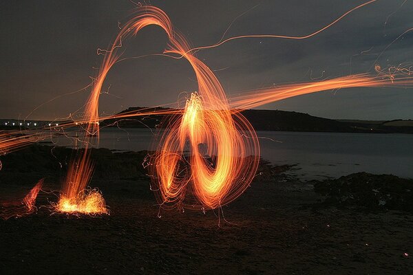 Bright sparks of a campfire on the shore