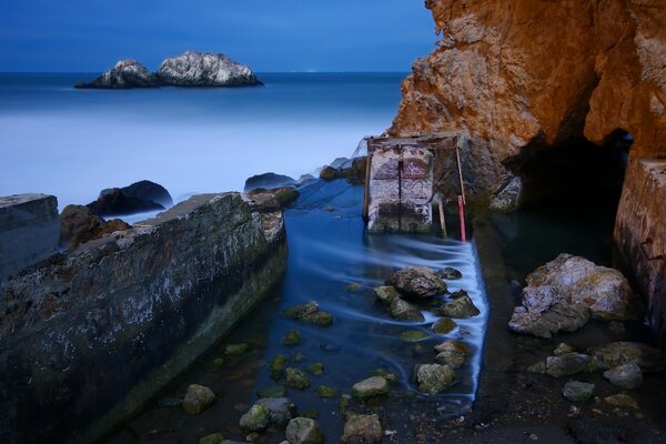 Felsen und Steine im blauen Wasser