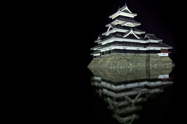 Die Reflexion einer Steinburg im Wasser