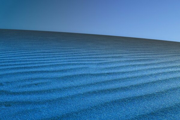 Samt mit blauem Sand auf blauem Hintergrund