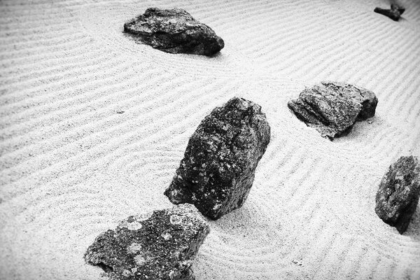 Black and white photo of stones on the sand
