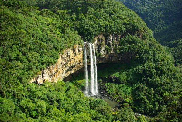Wasserfall in den Bergen auf einem Hintergrund von hellem Grün