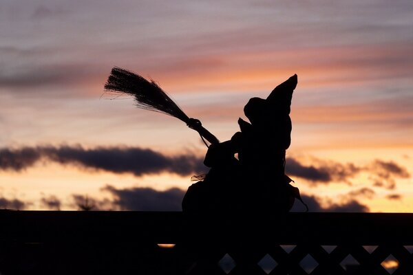 Figure of a witch on a broom against the sky