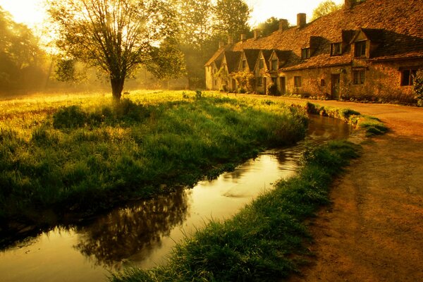 Casa in autunno vicino a uno stagno al tramonto