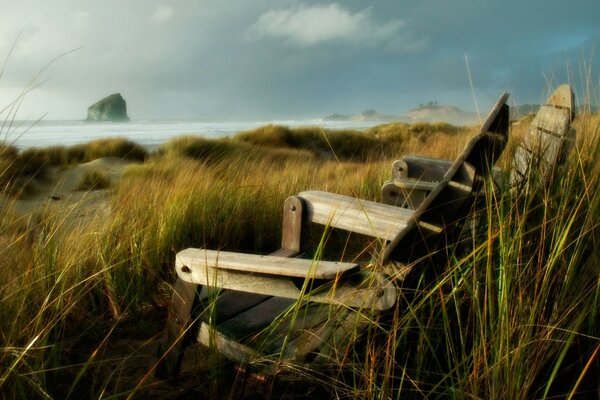 Wooden chairs on the shore of the bay