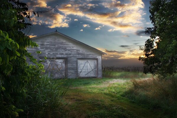 Barn at sunset in an open field