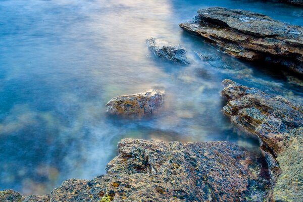 Steinstrand am blauen Wasser