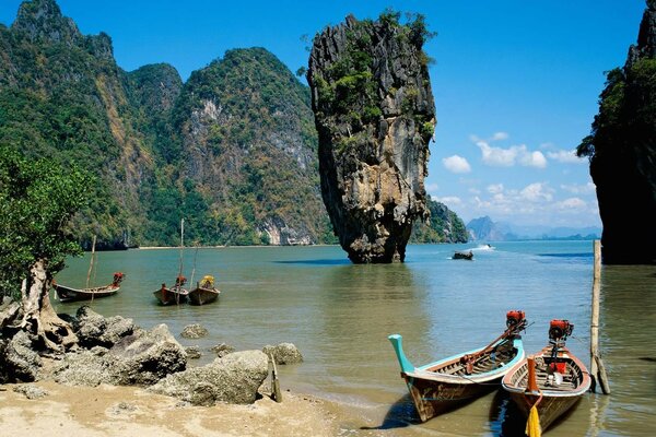 Barcos estacionados en el océano entre las rocas