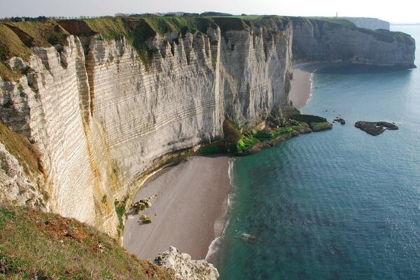 Sandy cliff, beach, emerald water