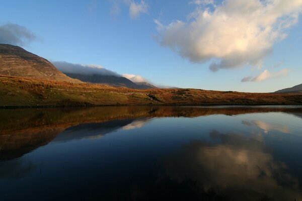 Reflection of the sky in the water against the background of mountains