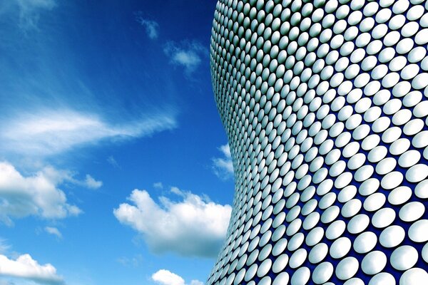 High-tech building on the background of light clouds