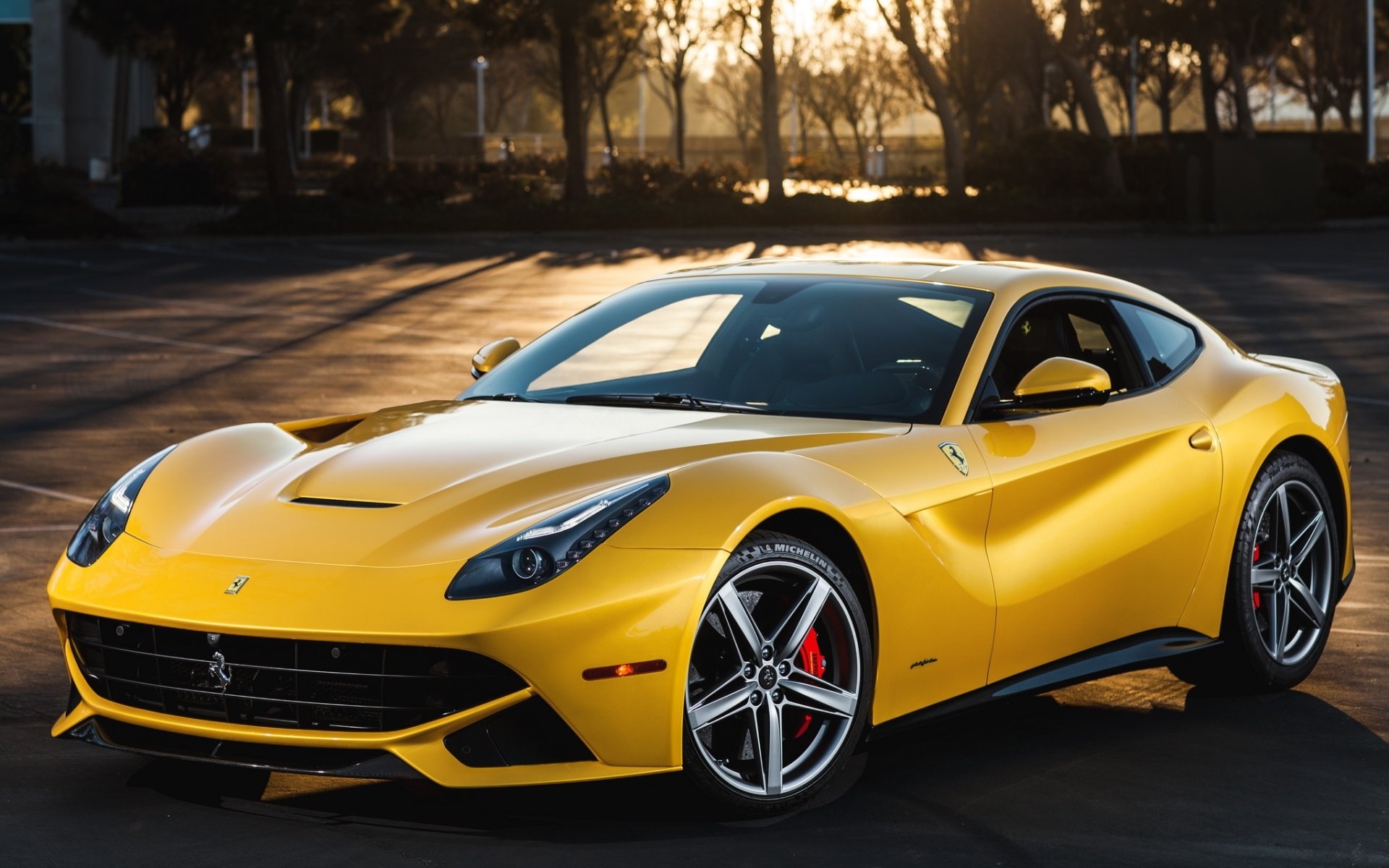 ferrari f12 berlinetta ferrari f12 berlineta supersamochód żółty przód drzewa zachód słońca tło