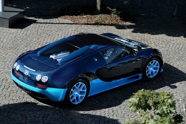 Niebieski Bugatti na parkingu z kostki brukowej