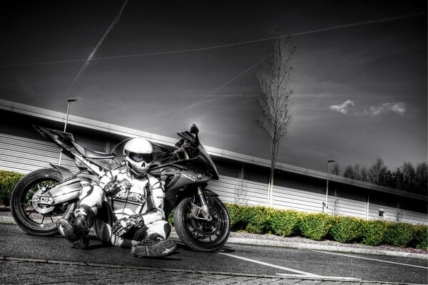 Moto deportiva BMW con un motociclista sentado al lado