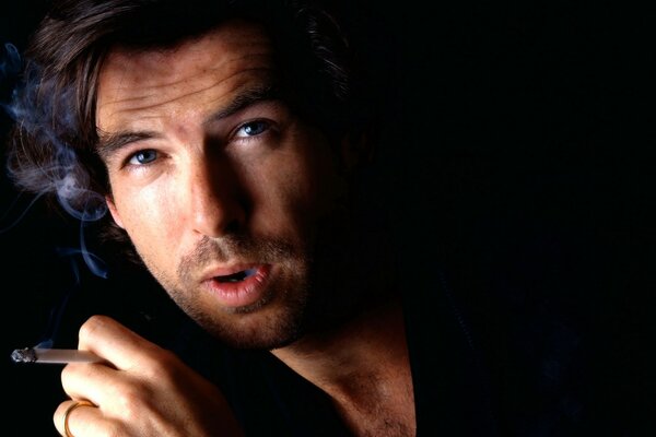 L attore Pierce Brosnan fuma