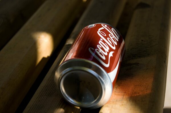 A lonely can of Coca-Cola on a bench